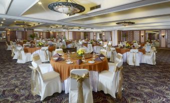 a large dining room filled with round tables and chairs , all set for a formal event at Jayakarta Hotel Jakarta