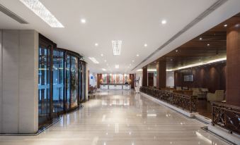 The main building or other areas feature a spacious lobby with an atrium and tiled floors at Ramada by Wyndham Beijing Airport