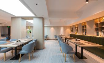 The restaurant features tables and chairs in the central room, as well as additional seating areas at Yiwu Mankalan Hotel (International Trade City Xinguanghui Branch)