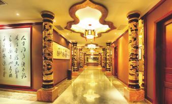 a long , elegant hallway with gold columns and chandeliers , leading to a door at the end at Silver Sea Hotel