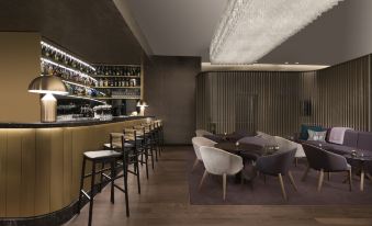 a modern bar with a wooden counter , white chairs , and a wine rack filled with bottles at Adina Apartment Hotel Nuremberg