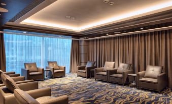 A spacious room with ample seating, including an armchair and a sofa, is provided for guests to unwind in at Amara Signature Shanghai