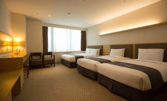 The bedroom includes double beds, a desk, and a chair positioned in front of a large window at Hotel Venue-G Seoul