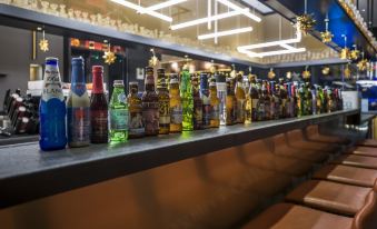 The bar is lined with a variety of different kinds and sizes of bottles, including liquor at CitiGO Hotel Beijing Tian'anmen Square