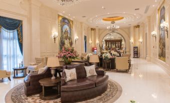 a luxurious hotel lobby with a large couch , couches , and chairs arranged around a coffee table at Wellington Hotel