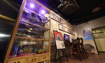 The room is old and has tables, chairs, and other items on the walls in front at Nostalgia Hotel (Beijing Lama Temple, Nanluogu Lane,)