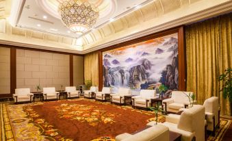 The large room is decorated in an oriental style and contains chairs and tables along the wall at Celebrity City Hotel