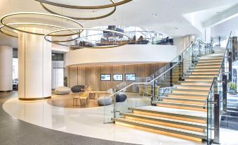 The hotel lobby features a central area with stairs and tables, connecting to various other rooms on each side at Novotel Century Hong Kong