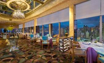 The restaurant features large windows and tables in the center, providing a view of the outside scenery from the interior at Regal Hongkong Hotel