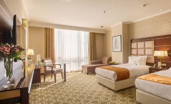 A spacious room is furnished with a bed, desk, and chair in the center at Espinas Palace Hotel Tehran