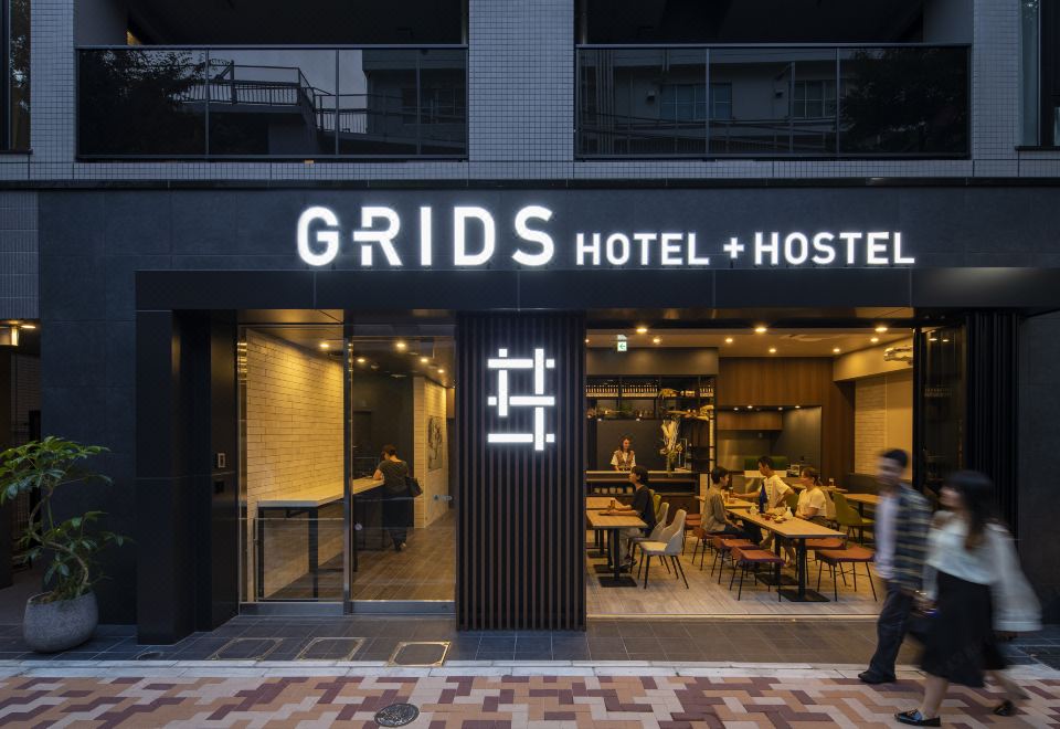 The view from outside shows the entrance to a restaurant, with tables and chairs arranged in front at Grids Tokyo Ueno Hotel&Hostel