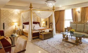 The middle room features a large bed with an ornate canopy, along with additional furniture at Espinas International Hotel