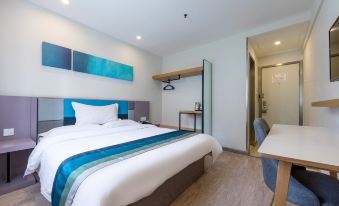 The bedroom features a large bed with modern furnishings and a flat-screen television on a nearby table at Motel Hotel (Shanghai Changping Road Metro Station)