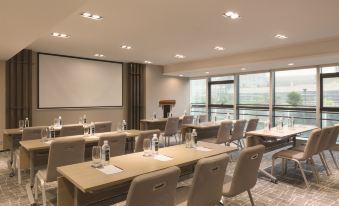 The conference space offers a spacious room with tables and chairs for meetings or other gatherings at Hyatt Place Shenzhen Airport