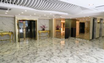 A spacious room with marble floors and a centrally located elevator adjacent to another set at Best Western Plus Hotel Kowloon