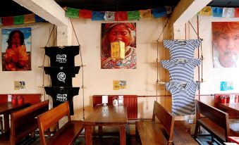 The room is decorated in an Asian style, featuring wooden tables and chairs suspended from the ceiling at Paoju Factory Youth Hostel (Beijing Summer Palace Subway Station Branch)