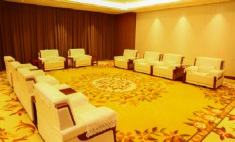 a well - lit conference room with multiple white couches arranged in a circle , creating a comfortable seating area at Sunshine Hotel