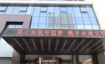 a modern building with chinese characters and a large sign , with two guards standing in front of the entrance at Orient Hotel