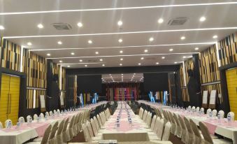 a large , empty banquet hall with white chairs and a long table in the center at Play Phala Beach Rayong