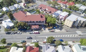 aerial view of a small town with multiple buildings and cars parked on the side of the road at Brisbane Backpackers Resort