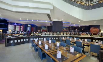 The restaurant features a spacious dining room with tables and chairs arranged in the center, ideal for business luncheons at Harbour Plaza Resort City