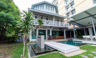 a large house with a swimming pool in the backyard , surrounded by lush green grass at Viva Hotel Songkhla