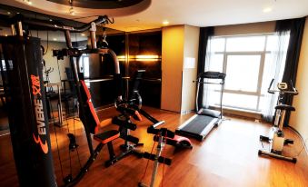 There is a gym adjacent to another area, featuring an exercise bike and a large window in the center at Da Zhong Airport Hotel
