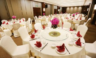 A spacious ballroom is arranged with tables and chairs for an event at Ramada by Wyndham Beijing Airport