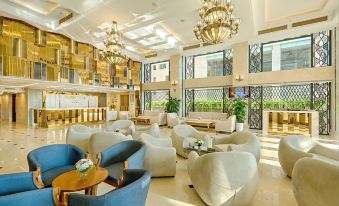 a modern , well - lit hotel lobby with white and blue furniture , including sofas and chairs , arranged around a central area at Paris Deli Danang Beach Hotel