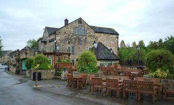 an outdoor dining area at a pub , with several tables and chairs arranged for guests to enjoy at Huddersfield North