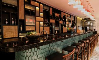 The restaurant's bar features a large wall behind it with two rows of items at Jinjiang Metropolo Shanghai Xintiandi Hotel