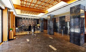 The main room of this hotel features a spacious lobby with an entrance and a wood-paneled ceiling at Zhenyue Hotel