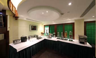 The room is spacious and contains tables and chairs arranged in the center, with an empty counter positioned alongside them at Seventh Heaven Hotel