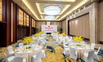 A ballroom is prepared with tables and chairs for an event at the hotel or another location at Ramada by Wyndham Heze