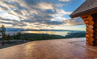 a wooden gazebo with a view of a lake and mountains , set against a cloudy sky at Coyote Bluff Estate