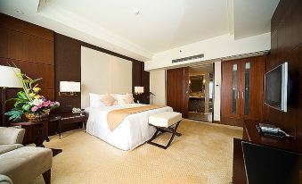 There is a large bed in the middle room with a white and brown color scheme on both sides at Hotel Fortuna