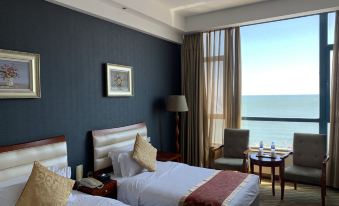 The bedroom features double beds, large windows, and a balcony with an ocean view at Beidaihe Bei Hua Yuan Sea View Hotel (Beidaihe Biluo Tower)