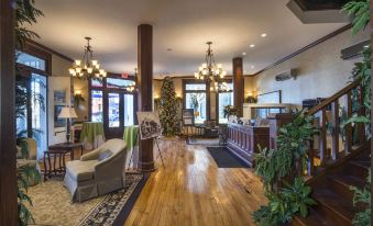 a spacious and well - lit hotel lobby with wooden floors , chandeliers , and large windows , as well as comfortable seating areas at The Inn at Wise