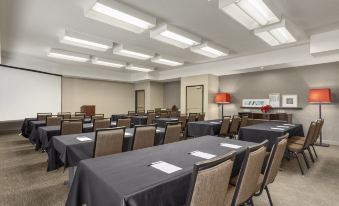 a conference room with tables and chairs , a fire extinguisher on the wall , and a large window at Comfort Inn & Suites