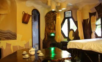 a room with a large window , a wooden table with tea cups on it , and a tiger statue at Crazy House