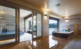a large , open room with wooden floors and large windows that offer views of the outdoors at Hakone Hotel