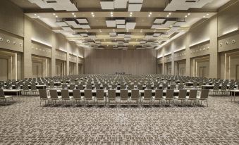 a large , empty conference room with rows of chairs and a stage at the front at Alila Solo