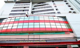 a modern building with a large glass window and red and green stripes , surrounded by people at Richmond Hotel Sylhet