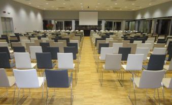 a large conference room with rows of chairs arranged in a semicircle , ready for a meeting or event at Cosmopolitan Hotel