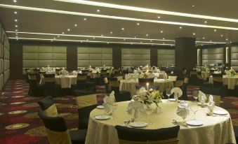 a large banquet hall with multiple round tables set up for a formal event , possibly a wedding reception at Radisson Hotel Agra