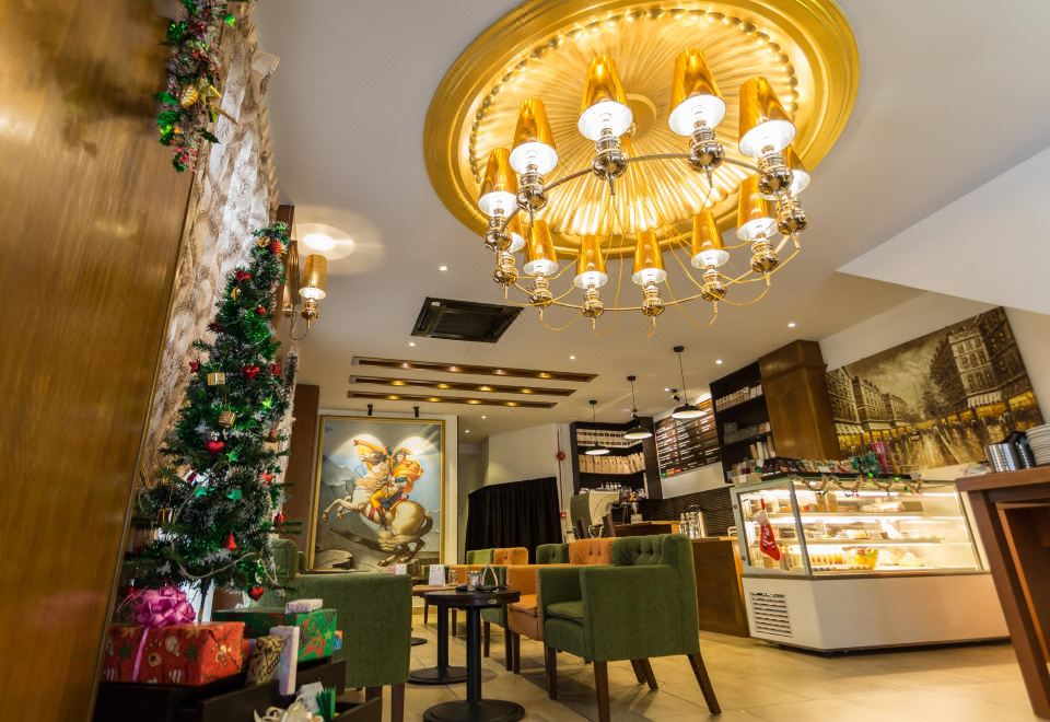 a modern café interior with wooden furniture , green chairs , and a large chandelier , decorated for the holiday season at Z Hotel