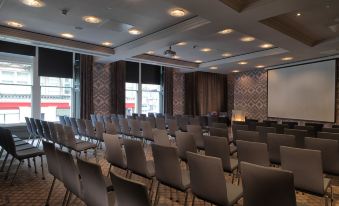 a conference room with rows of chairs arranged in a semicircle , and a projector screen on the wall at Malmaison Dundee