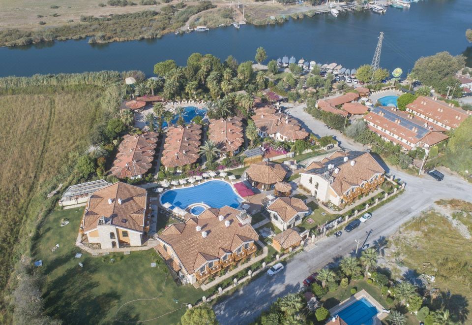 aerial view of a large resort with multiple buildings and a swimming pool , situated near a river at Dalyan Live Spa Hotel