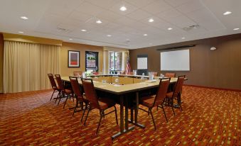 a conference room with a large table surrounded by chairs and a flag on the wall at Courtyard Oneonta Cooperstown Area