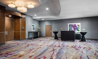 a modern office space with large windows , gray walls , and a colorful carpet , featuring a reception desk , waiting area , and artwork at Courtyard Omaha Bellevue at Beardmore Event Center